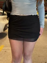 Minifalda negra de tul con diseño semi transparente en el borde inferior y pretina elástica.