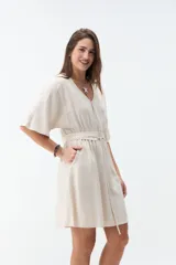 Vestido corto beige con escote en V, mangas cortas amplias y cintura elastizada con lazo ajustable.