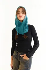 Top de manga larga color marrón, confeccionado en tejido acanalado con cuello bote. Presenta costuras decorativas expuestas a lo largo de las mangas, creando un efecto de relieve.