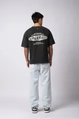 Remera de algodón con efecto de lavado gastado, corte holgado y diseño deportivo. Presenta el número 15 estampado en el frente con acabado desgastado y detalles de costuras blancas en los hombros y laterales.