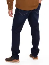 Pantalón jeans de corte modern fit y tiro medio, confeccionado en denim azul oscuro con costuras en contraste. Presenta cierre de cremallera y botón, con tecnología Natural Flex para mayor flexibilidad y comodidad.