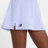 Short deportivo New Balance color lila claro, con cintura elástica y logo NB en el lateral inferior izquierdo.