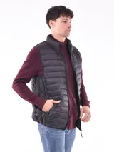 Chaleco acolchado color negro, con cierre frontal y cuello alto.