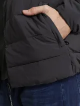 Campera puffer Calvin Klein color gris oscuro, con cuello alto, cierre frontal con cremallera, bolsillos laterales con cierre, puños elásticos y logo en la manga.