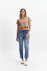 Jean straight de tiro medio, color azul denim, con corte recto y ruedo desflecado.