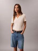 Shorts tipo bermuda de corte relajado y talle alto, confeccionados en una mezcla de algodón y lino. Presentan un diseño clásico de cinco bolsillos, cierre con cremallera y botón, y pespuntes decorativos.