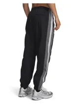Pantalón deportivo Under Armour modelo ICN WVN Track Jogger, de color negro con franjas laterales grises y blancas. Incorpora tecnología UA Storm que repele el agua, tejido ligero de nailon con textura arrugada, cintura elástica y puños ajustados.