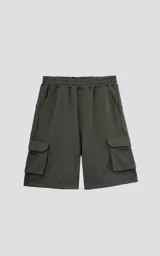 Bermuda de algodón rústico color verde militar, de calce oversize, con cintura elástica y bolsillos cargo con cierre en los laterales.