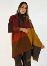 Pashmina de tejido de punto con diseño de bloques de color en tonos tierra, incluyendo bordó, naranja, mostaza y marrón. Presenta terminaciones acanaladas en los extremos.