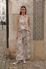 Pantalón gris con estampado de lobos, labios y estrellas, de corte palazzo, con cintura elástica y bolsillos laterales.