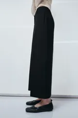 Pantalón de tiro medio confeccionado en viscosa, con diseño de corte recto y largo tobillero. Presenta cintura con trabillas, bolsillos laterales y bolsillos de vivo en la parte posterior. Cierre frontal con cremallera, botón y ganchos metálicos.