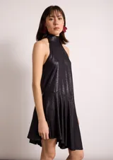 Vestido corto blanco con lunares negros, cuello halter y corte evasé.