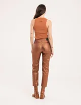 Pantalón negro estilo jeanero confeccionado en gabardina elastizada con terminación metalizada, pierna recta con largo por arriba del tobillo, cierre delantero y botón.