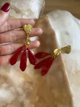 Aros colgantes con forma de flor, de color rojo y dorado.