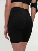 Calza corta deportiva tiro alto, color verde oscuro, confeccionada en tejido elástico con costuras reforzadas que aportan soporte y comodidad durante el entrenamiento.