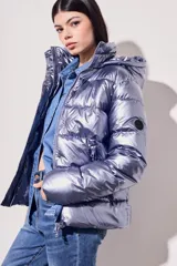 Campera puffer negra con acabado brillante, diseño acolchado, capucha integrada y cierre frontal con botones a presión.