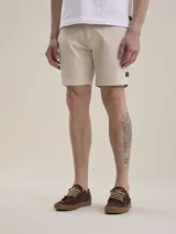 Bermuda de gabardina color beige, de corte casual y diseño liso, con bolsillos laterales y traseros.