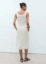 Top de crochet color blanco, sin mangas, con cuello escotado y tirantes anchos.