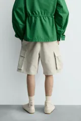 Bermuda cargo de algodón color beige claro, con corte relajado, bolsillos laterales de parche con solapa y bolsillos traseros de vivo.