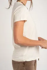 Remera de algodón peinado color marfil, de manga corta y corte al cuerpo, con escote en V ribeteado con hilo dorado.