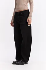 Jean de corte balloon con tiro alto y silueta amplia que se estrecha ligeramente hacia el tobillo. Presenta un diseño de cinco bolsillos, cierre frontal con botón y bragueta, y costuras reforzadas.