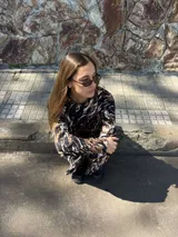Conjunto de dos piezas compuesto por un sweater de manga larga y pantalón de corte recto, ambos con estampado abstracto en tonos marrón, negro y blanco.
