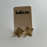 Par de aros dorados con forma cuadrada y textura labrada.