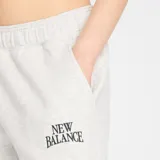 Pantalón de jogging New Balance de tiro alto, con corte amplio y holgado tipo barrel. Presenta cintura elástica con cordón interno, bolsillos laterales y estampado gráfico de la marca en la pierna.