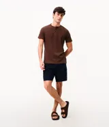 Bermuda de sarga negra de corte recto y holgado para hombre, con bolsillos cargo laterales con solapa, cintura con pasadores y cierre frontal con botón y cremallera.