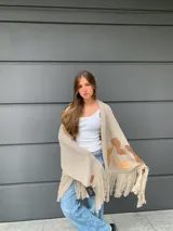 Chal beige con flecos y apliques marrones.