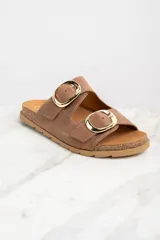 Sandalias marrones de cuero con dos tiras anchas ajustables con hebillas doradas. La plantilla es de corcho y la suela es de goma.