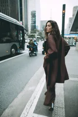 Abrigo largo de Zara confeccionado en hilatura con lana, de color marrón oscuro. Cuenta con cuello solapa, manga larga, bolsillos de vivo en el delantero y cierre frontal con dos botones.