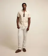 Camisa de hombre de manga corta color marrón, confeccionada en lino y algodón. Presenta cuello clásico, botonadura frontal, bolsillo en el pecho y mangas con botón para enrollar.