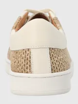 Zapatillas urbanas Hush Puppies modelo Merano, con diseño que combina cuero sintético en color blanco y paneles laterales de tejido tipo rafia en tono natural. Presentan suela de goma blanca y cierre mediante cordones.