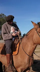 Sweater de punto grueso color topo, con cuello alto y corte holgado.