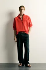 Camisa polo relaxed fit confeccionada en tejido de algodón y lino, color azul marino oscuro. Cuenta con cuello solapa, cierre frontal parcial con botones, bolsillo aplicado en el pecho y manga larga con puños abotonados.