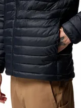 Campera puffer con capucha marca Columbia, modelo Powder Pass Hooded, en color negro con diseño acolchado horizontal. Cuenta con cierre frontal y el logo de la marca bordado en el pecho.