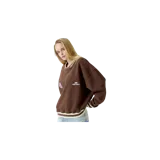 Buzo crewneck oversize marrón de Eme Studios, con cuello en V simulado, detalles en rib blanco y marrón en cuello, puños y ruedo. Presenta un parche redondo estampado en el pecho derecho y el logo de la marca bordado en el pecho izquierdo.