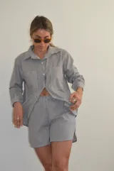 Camisa a rayas verticales blancas y negras, de corte holgado y manga larga.