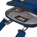 Bolso tipo morral de la marca Caterpillar, color azul marino, con diseño compacto, cierre principal y correa ajustable. Presenta el logo de la marca en el frente y una etiqueta lateral distintiva.