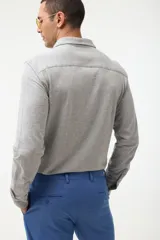 Camisa azul marino de piqué con cuello clásico, manga larga y cierre frontal con botones.