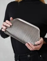 Cartera tipo clutch de mano con diseño estructurado y silueta redondeada. Presenta un acabado plateado metalizado con textura de plisado tubular vertical y cierre de marco rígido.