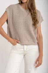 Chaleco sin mangas de tejido de punto color rosado pálido, con textura calada y acabado lurex, corte al cuerpo y cuello redondo.