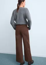 Pantalón de jean color marrón, de corte wide leg y tiro alto, con costuras frontales verticales y cierre oculto.