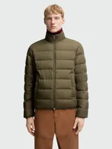 Chaqueta acolchada Moncler modelo Baudinet, color verde oliva, con cierre frontal completo, cuello alto y diseño de costuras horizontales. Incluye bolsillos laterales y logo de la marca en la manga.