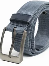 Cinturón de lona color negro con hebilla metálica rectangular en tono plateado oscuro.