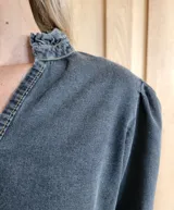 Blusa de algodón con cuello mao y volados, mangas largas con puños elásticos y corte holgado.