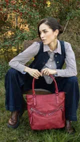 Cartera roja de símil cuero con textura croco, doble cierre metálico frontal y bolsillo trasero con cierre. Incluye correa corta para el hombro y correa larga desmontable y regulable.