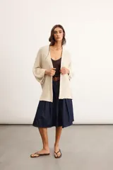 Saco tejido de punto con silueta oversize, color salmón, de manga caída y largo por debajo de la cadera.