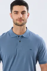Remera polo de piqué de algodón color azul, de manga corta, con cuello camisero, cierre frontal de dos botones y pequeño logo bordado en el pecho.